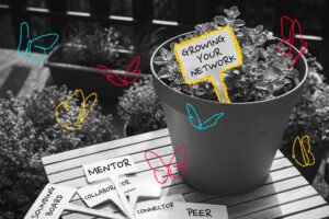 A potted plant with a stake that says "Grow your network." There are several unused stakes on the table that say sounding board, mentor, collaborator, peer, and connector.